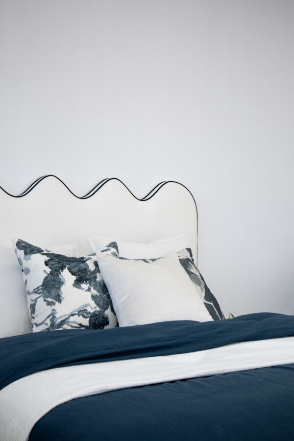 Curved linen bedhead with contrast piping